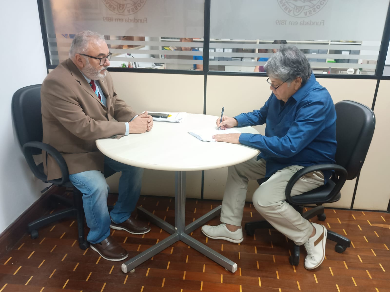 Momento histórico para a salvaguarda da memória paraense: o Presidente do IHGP, Professor Álvaro Negrão do Espírito Santo (à esquerda), recepciona o Procurador-Geral da ALEPA, Doutor Justiniano Alves Júnior (à direita), para a subscrição formal do Termo de Cooperação visando às obras prioritárias de restauro e conservação do Solar Barão de Guajará. O ato sela o compromisso institucional com a integridade física de nossa sede secular.